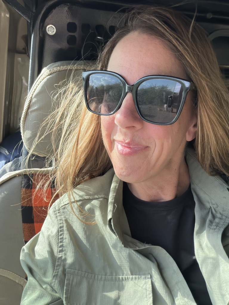 Close-up of a woman wearing sunglasses during a safari in Kenya, enjoying a luxury African travel experience