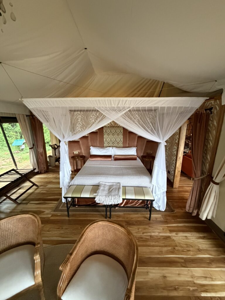 Luxury safari lodge bedroom with canopy bed and open-air design in Kenya, showcasing upscale safari accommodations